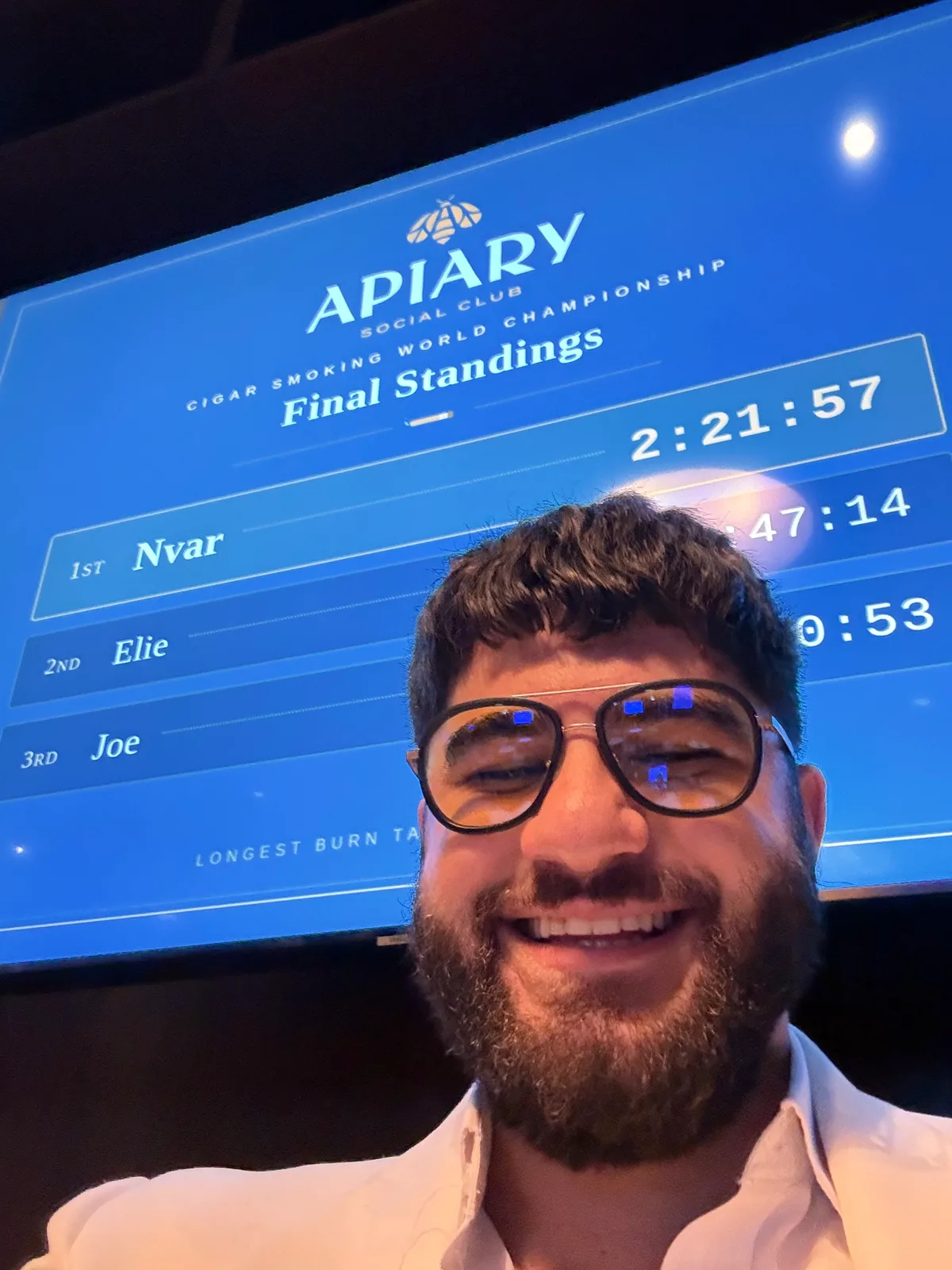 Nvar Sinclair smiling in front of the Apiary Social Club final standings board showing 1st place, Nvar, 2:21:57 — CSWC Omaha qualifier