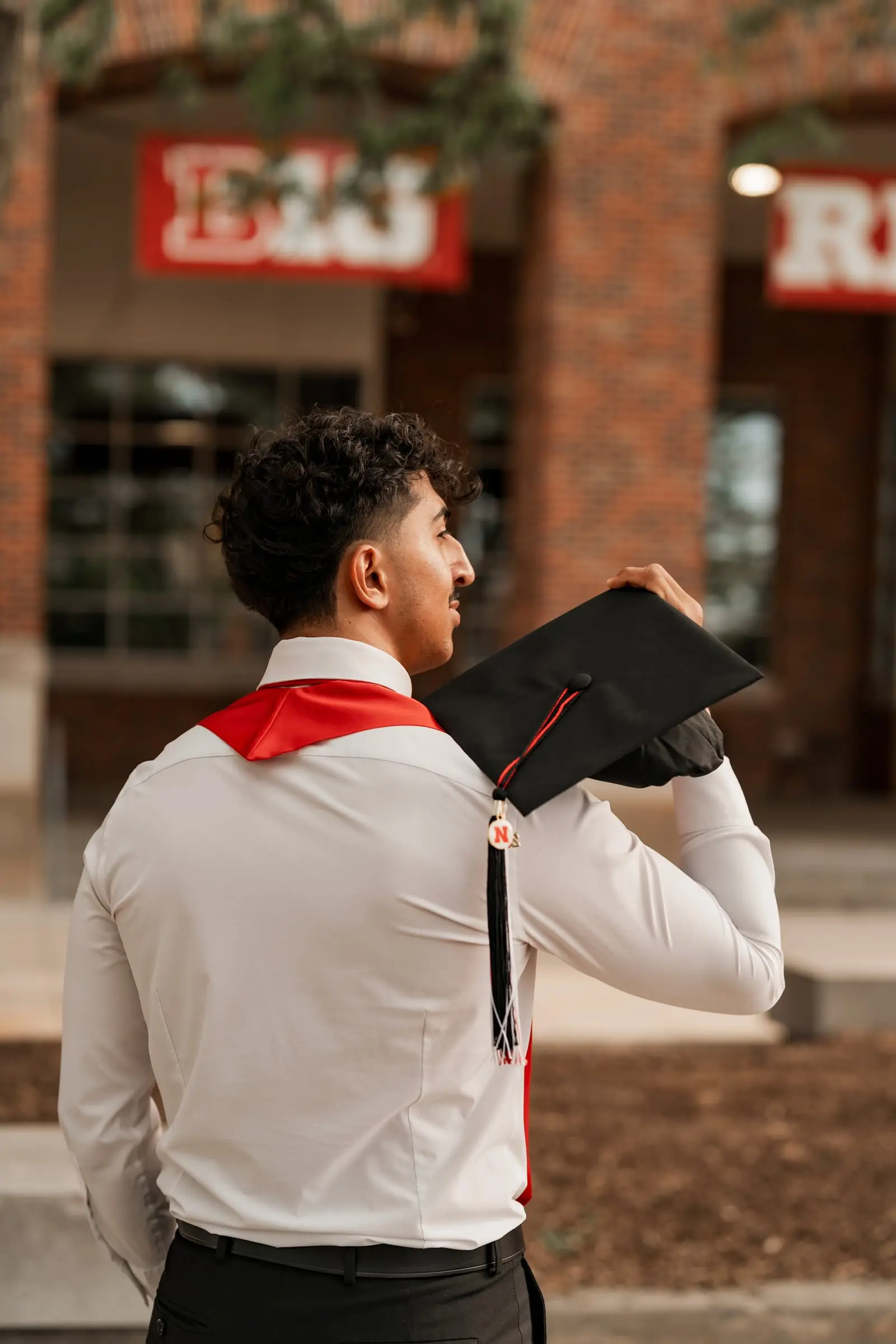 UNL graduation photos on campus in Lincoln, Nebraska — senior in regalia photographed by NVAR Studios